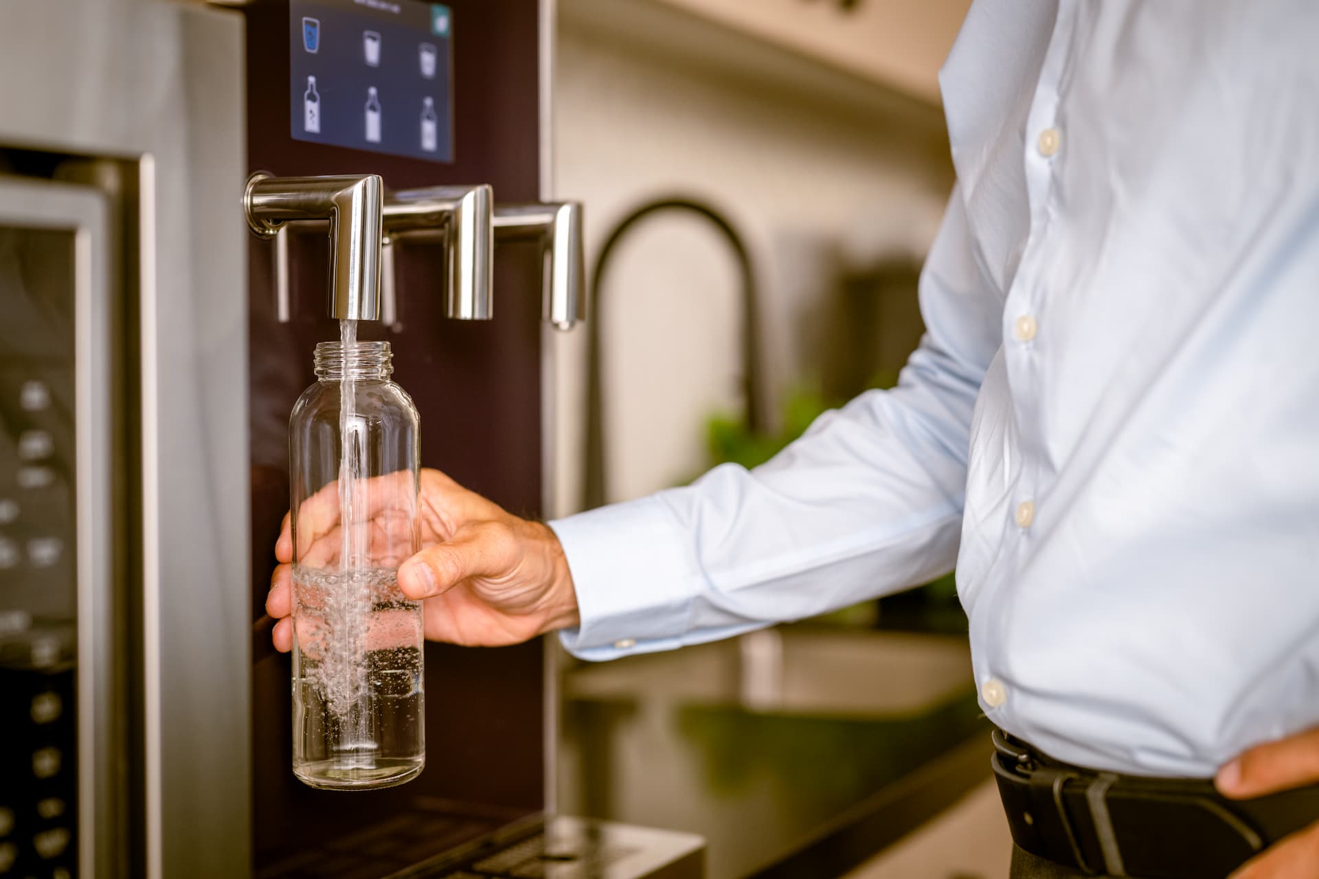 Photo of an individual using a Culligan water treatment solution.